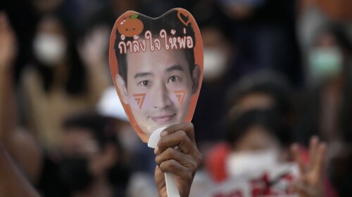 A supporter of the Move Forward Party holds a paper fan of Pita Limjaroenrat, the leader of the Move Forward Party, during a protest in Bangkok, Thailand, Friday, July 14, 2023. The protesters are irate that Pita Limjaroenrat, the leader of the Move Forward Party that placed first in May's general election, failed to be named prime minister by Parliament on Wednesday because only a handful of members from the non-elected Senate gave him their support. (AP Photo/Sakchai Lalit)