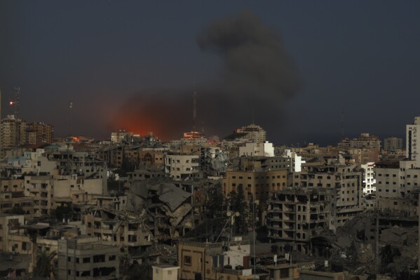 Long exposure photo shows destroyed buildings with fire and smoke rise following Israeli airstrikes on Gaza City, Monday, Oct. 30, 2023. (AP Photo/Abed Khaled)
