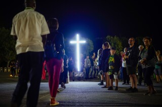 The faithful attend a 'Via Crucis' (Way of the Cross) at the St. Gabriele dell'Addolorata sanctuary in Isola del Gran Sasso near Teramo in central Italy Friday, July 29, 2023. In Italy, centuries-old churches dot the landscape, sanctuaries and processions draw crowds, and nearly 80% of the population profess themselves Catholic. But to the majority, it's an affiliation in name and tradition, with little adherence to doctrine or practice. (AP Photo/Domenico Stinellis)