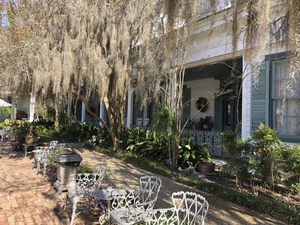 Spanish moss hangs from trees lining a courtyard at The Myrtles, a former antebellum home slave plantation turned wedding venue and tourist site, Tuesday, Nov. 16, 2021, in St. Francisville, La. The Myrtles sits just 20 miles away from where men toil in the fields of Angola. (AP Photo Margie Mason)