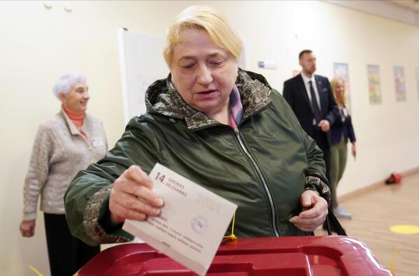 A woman casts her ballot at a polling station during general elections in Riga, Latvia, Saturday, Oct. 1, 2022. Polling stations opened Saturday in Latvia for a general election influenced by neighboring Russia’s attack on Ukraine, disintegration among the Baltic country’s sizable ethnic-Russian minority and the economy, particularly high energy prices. (AP Photo/Roman Koksarov)
