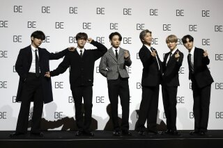 File---File photo taken Nov.20, 2020 members of South Korean K-pop band BTS pose for photographers during a press conference to introduce their new album "BE" in Seoul, South Korea. (AP Photo/Lee Jin-Man, file)
