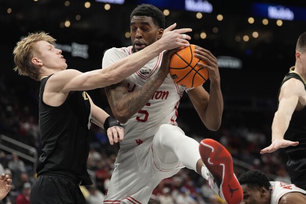 Houston's Ja'Vier Francis (5) grabs a rebound as Colorado's Trevor Baskin, left, defendsduring the first half of an NCAA college basketball game in the quarterfinal round of the Big 12 Conference tournament, Thursday, March 13, 2025, in Kansas City, Mo. (AP Photo/Charlie Riedel)