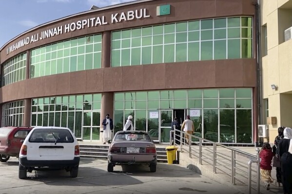 In this image made from video, people stand in front of a hospital after a bomb explosion in the west of Kabul, Afghanistan, Wednesday, Nov. 8, 2023. The Islamic State group claimed responsibility for a minibus explosion in the Afghan capital late on Tuesday that killed at least seven people. The Sunni militant group said its members detonated an explosive device on the bus carrying Shiite Muslims. (AP Photo)