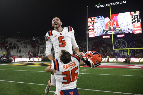 Illinois place kicker Caleb Griffin (5) celebrates with long snapper Lane Hansen (36) after Griffin kicked a game-winning field goal as time expired during the second half of an NCAA college football game against Maryland, Saturday, Oct. 14, 2023, in College Park, Md. Illinois won 27-24. (AP Photo/Nick Wass)