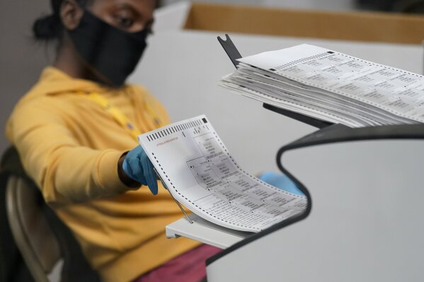 A county election worker scans mail-in ballots at a tabulating area at the Clark County Election Department, Thursday, Nov. 5, 2020, in Las Vegas. (AP Photo/John Locher)