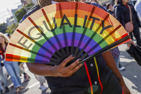 A person holds a fan that reads "Equality" during the 31st annual San Francisco Dyke March on Saturday, June 24, 2023. (Santiago Mejia/San Francisco Chronicle via AP)