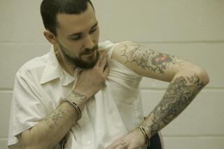 FILE - Inmate Michael Tisius, sentenced to death in the killing of two jail officers, shows his tattoos during an interview at Potosi Correctional Center, Missouri's maximum security prison where condemned men live in the general prison population in Mineral Point, Mo., on Jan. 11, 2007. A federal judge on Wednesday, May 31, 2023, halted next week's scheduled execution of Tisius, a man convicted of killing two Missouri jailers, amid questions about the literacy of a juror in the case. (AP Photo/Jeff Roberson, File)