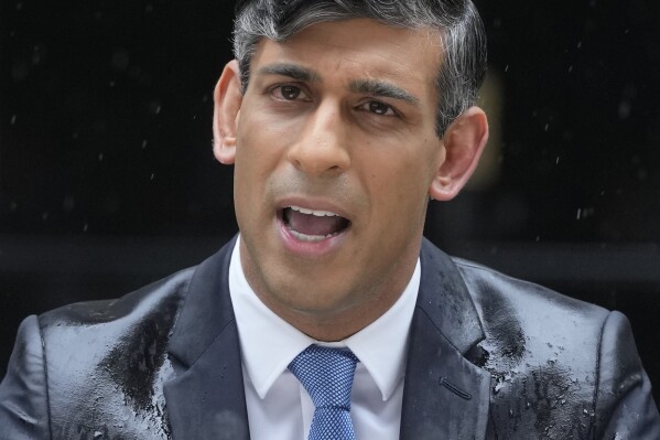 Britain's Prime Minister Rishi Sunak speaks to the media, as heavy rain falls, outside 10 Downing Street in London Wednesday, May 22, 2024, as he announces that he is to call a General Election for July 4. (AP Photo/Kin Cheung)