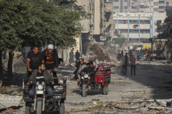Palestinians flee to the southern Gaza Strip at the main road in Gaza City on Friday, Nov. 24, 2023, as the temporary ceasefire took effect. (AP Photo/Mohammed Hajjar)