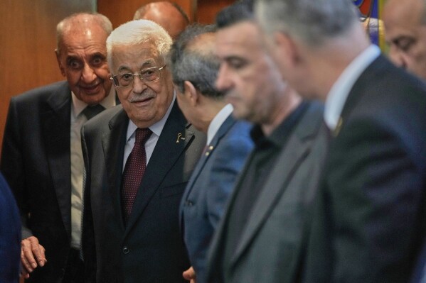 Palestinian President Mahmoud Abbas, centre, leaves after his meeting with Lebanese Parliament Speaker Nabih Berri, left background, in Beirut, Lebanon, Thursday, May 22, 2025. (AP Photo/Hussein Malla)