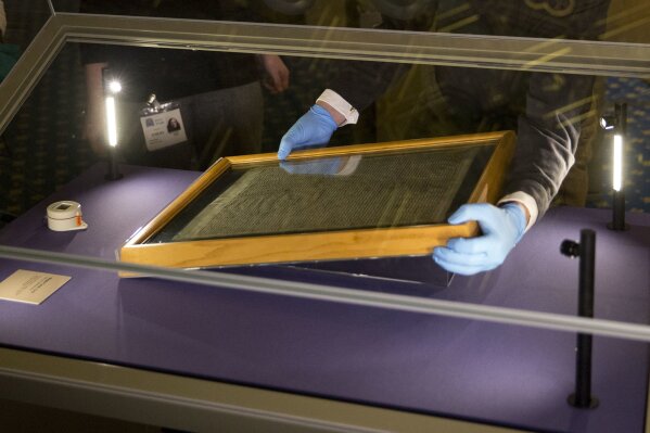 
              FILE - In this file photo dated Thursday, Feb. 5, 2015, The Salisbury Cathedral 1215 copy of the Magna Carta is installed in a glass display cabinet marking the 800th anniversary of the sealing of Magna Carta at Runnymede in 1215, in Salisbury, England.  British police said Friday Oct. 26, 2018, that cathedral alarms sounded Thursday afternoon when a person tried to smash the glass display box surrounding the Magna Carta in Salisbury Cathedral, and a man has been arrested. (AP Photo/Matt Dunham, FILE)
            