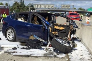 FILE - In this March 23, 2018, file photo provided by KTVU, emergency personnel work a the scene where a Tesla electric SUV crashed into a barrier on U.S. Highway 101 in Mountain View, Calif.  The National Transportation Safety Board says the driver of a Tesla SUV who died in a Silicon Valley crash two years ago was playing a video game on his smartphone at the time. Chairman Robert Sumwalt said at the start of a hearing Tuesday, Feb. 25, 2020 that partially automated driving systems like Tesla's Autopilot cannot drive themselves. Yet he says drivers continue to use them without paying attention. (KTVU-TV via AP, File)