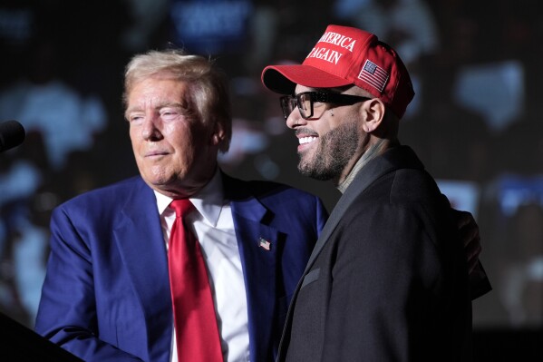 Republican presidential nominee former President Donald Trump, left, greets Nicky Jam during a campaign event at the World Market Center, Friday, Sept.13, 2024, in Las Vegas. (AP Photo/Alex Brandon)