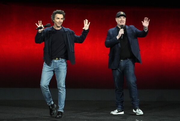 Shawn Levy, left, director of the upcoming film "Deadpool & Wolverine," and Marvel Studios president Kevin Feige wave to the audience during the Walt Disney Studios presentation at CinemaCon 2024, Thursday, April 11, 2024, at Caesars Palace in Las Vegas. (AP Photo/Chris Pizzello)