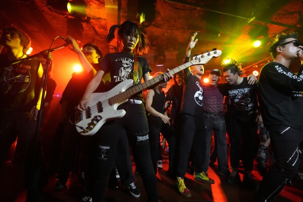 The crowd joins Chinese punk rock band Gum Bleed as they perform during a punk festival in Hangzhou, China, Friday, Jan. 17, 2025. (AP Photo/Aaron Favila)