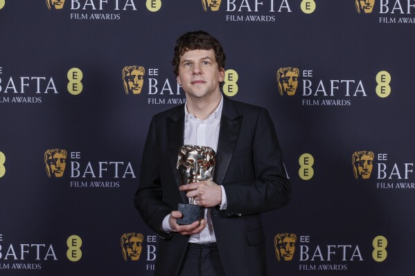 Jesse Eisenberg poses with the best supporting actor award he received on behalf of Kieran Culkin for "A Real Pain" at the 78th British Academy Film Awards, BAFTA's, in London, Sunday, Feb. 16, 2025. (Photo by Joel C Ryan/Invision/AP)