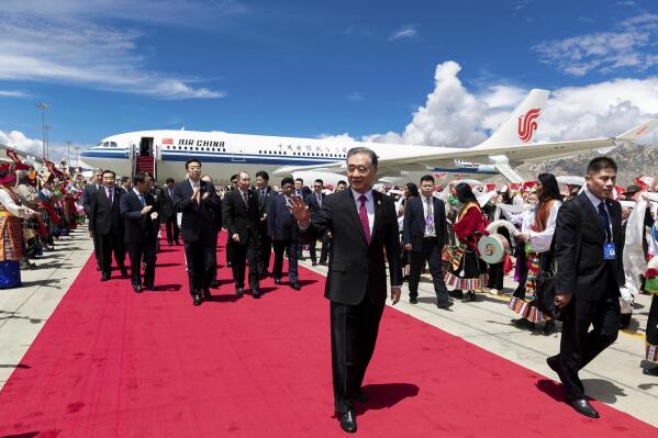 In this photo released by Xinhua News Agency, Wang Yang, chairman of the Chinese People's Political Consultative Conference (CPPCC), center, waves as he arrives in Lhasa to attend the ceremony to commemorate the 70th anniversary of Tibet liberation, in Lhasa in western China's Tibet Autonomous Region on Wednesday, Aug. 18, 2021. The top Chinese official said Thursday, Aug. 19, that “all-round efforts” are needed to ensure Tibetans speak standard spoken and written Chinese and share the “cultural symbols and images of the Chinese nation.” (Huang Jingwen/Xinhua via AP)