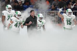North Texas coach Seth Littrell runs onto the field with the team for an NCAA college football game against UTSA for the Conference USA championship in San Antonio, Friday, Dec. 2, 2022. (AP Photo/Eric Gay)