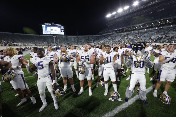 Washington players celebrate after defeating Michigan State in an NCAA college football game, Saturday, Sept. 16, 2023, in East Lansing, Mich. Washington won 41-7. (AP Photo/Al Goldis)
