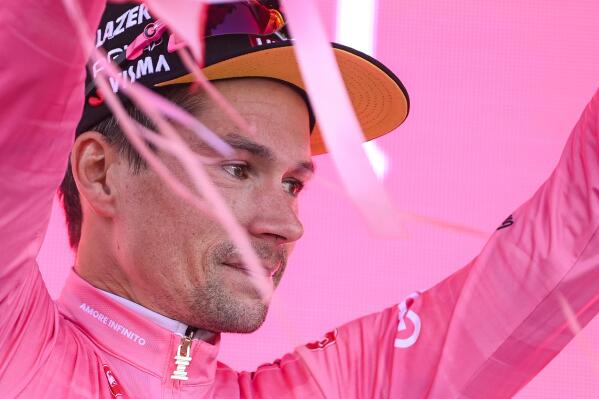 Slovenia's Primoz Roglic wears the pink jersey of the overall leader as he celebrates on the podium at the end of the 20th stage of the Giro d'Italia cycling race, an individual mountain time trial from Tarvisio to Monte Lussari, Italy, Saturday, May 27, 2023. Roglic all but secured the Giro d’Italia title on Saturday by overtaking leader Geraint Thomas on the penultimate stage despite having a mechanical problem on the mountain time trial. (Fabio Ferrari/LaPresse via AP)