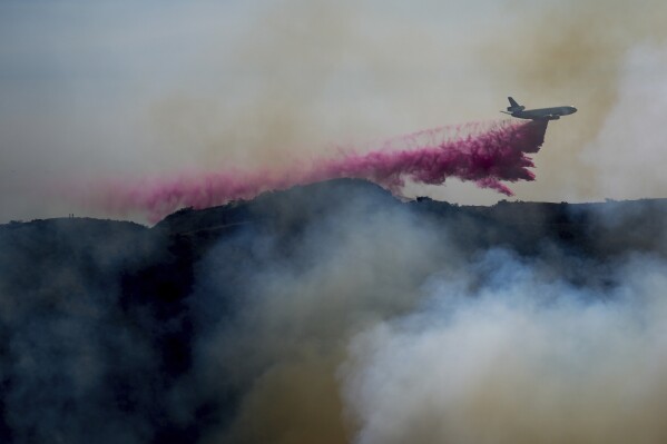 Fire retardant covers a backyard in Mandeville Canyon during the Palisades Fire, Jan. 11, 2025, in Los Angeles. (AP Photo/Eric Thayer)