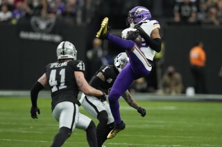 Minnesota Vikings wide receiver Justin Jefferson (18) makes a catch as Las Vegas Raiders safety Marcus Epps (1) defends during the first half of an NFL football game, Sunday, Dec. 10, 2023, in Las Vegas. (AP Photo/John Locher)