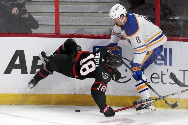 Buffalo Sabres defenceman Robert Hagg checks Ottawa Senators left wing Tim Stutzle along the boards during the second period of an NHL hockey game, Tuesday, Jan. 25, 2022 in Ottawa, Ontario. (Adrian Wyld/The Canadian Press via AP)