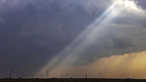 FILE - Sunlight filters through storm clouds onto a wind turbine as severe weather rolls through the midwest on April 4, 2023, south of Stuart, Iowa. The U.S. Department of Agriculture announced a nearly $11 billion investment on Tuesday, May 16, to help bring affordable clean energy to rural communities throughout the country. (Chris Machian/Omaha World-Herald via AP, File)