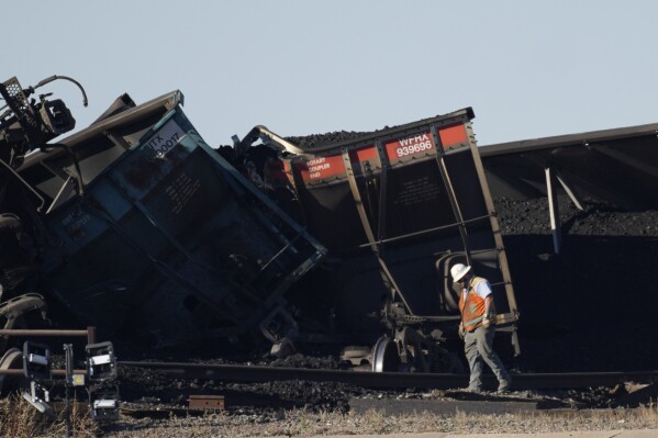 FILE - Workers toil to clear rail cars that derailed and collapsed a bridge over Interstate 25 northbound, Monday, Oct. 16, 2023, north of Pueblo, Colo. Federal investigators said Thursday they’re looking at BNSF Railway’s inspection and maintenance practices as the investigate the accident that killed a truck driver passing beneath the train. (AP Photo/David Zalubowski, File)
