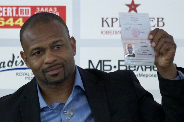 FILE - In this Oct. 28, 2015, file photo, former world boxing champion Roy Jones Jr. shows off his Russian passport during a news conference in Moscow, Russia. Mike Tyson and Jones got permission from California's athletic commission to return to the boxing ring next month because their fight would be strictly an exhibition of their once-unparalleled skills. (AP Photo/Ivan Sekretarev, File)