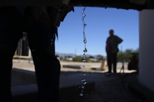 Water drips from a faucet as water operator Robert Tipton checks equipment for a well at the Wenden Domestic Water Improvement District's offices Tuesday, Oct. 17, 2023, in Wenden, Ariz. (AP Photo/John Locher)