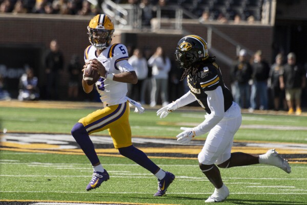 LSU quarterback Jayden Daniels, left, runs from Missouri linebacker Ty'Ron Hopper, right, during the first quarter of an NCAA college football game Saturday, Oct. 7, 2023, in Columbia, Mo. (AP Photo/L.G. Patterson)
