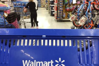 
              FILE - In this June 5, 2017, file photo, customers shop for food at Walmart in Salem, N.H. Walmart says it will no longer sell firearms and ammunition to people younger than 21. The retailer's new policy comes after Dick's Sporting Goods announced earlier Wednesday, Feb. 28, 2018, that it would restrict the sale of firearms to those under 21 years old. It didn't mention ammunition. Walmart says the decision came after a review of its firearm sales policy in light of the mass shooting at a high school in Parkland, Florida. (AP Photo/Elise Amendola, File)
            