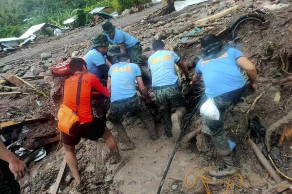 In this handout photo provided by the Philippine Coast Guard, rescuers retrieve bodies during the search and rescue operations due to landslides caused by Tropical Storm Nalgae in Barangay Kushong, Datu Odin Sinsuat, Maguindanao province, southern Philippines on Friday Oct. 28, 2022. Several people died while others were missing in flash floods and landslides set off by torrential rains from Tropical Storm Nalgae that swamped a southern Philippine province overnight and trapped some residents on their roofs, officials said Friday.(Philippine Coast Guard via AP)