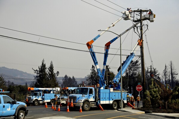 FILE - A Pacific Gas & Electric crew works at restoring power following a wildfire along the Old Redwood Highway on Oct. 11, 2017, in Santa Rosa, Calif. On Wednesday, Sept. 13, 2023, the California Public Utilities Commission released two proposed decisions for increasing rates for customers of Pacific Gas & Electric. The commission is scheduled to make its decision in November. (AP Photo/Eric Risberg, File)