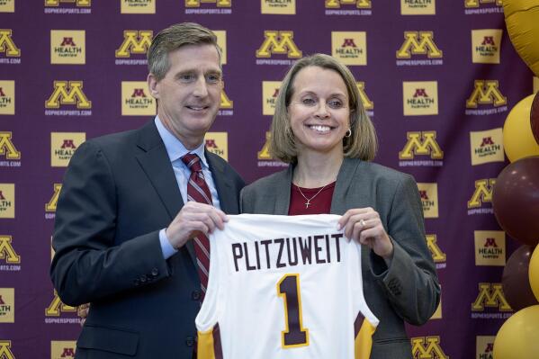 University of Minnesota Athletic Director Mark Coyle, left, introduces Dawn Plitzuweit, the schools new women's NCAA college basketball head coach, during a press conference in Minneapolis, Monday, March 20, 2023. (Elizabeth Flores/Star Tribune via AP)