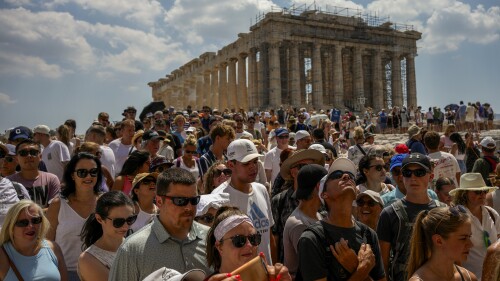 Atop the Acropolis ancient hill, tourists visit the Parthenon temple, background, in Athens, Greece, Tuesday, July 4, 2023. Crowds are packing the Colosseum, the Louvre, the Acropolis and other major attractions as tourism exceeds 2019 records in some of Europe’s most popular destinations. While European tourists helped the industry on the road to recovery last year, the upswing this summer is led largely by Americans, who are lifted by a strong dollar and in some cases pandemic savings. (AP Photo/Thanassis Stavrakis)