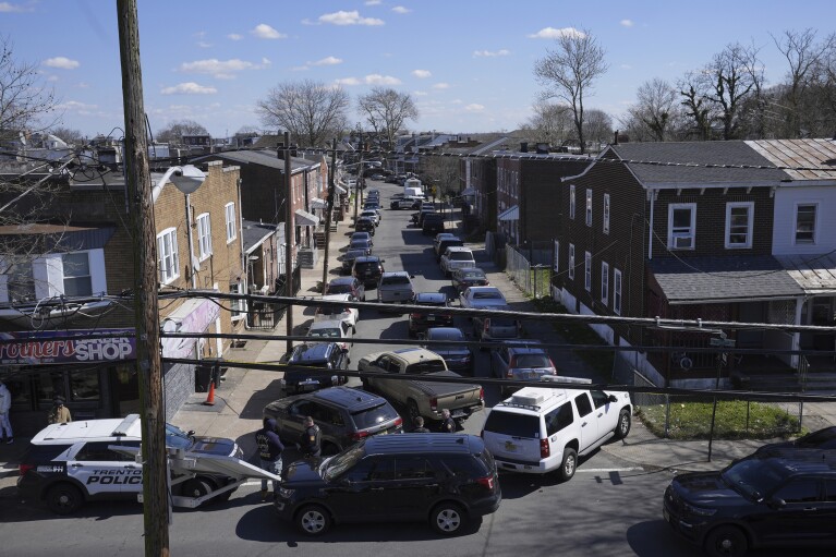 Police surround a home in Trenton, N.J. on Saturday, March 16, 2024. A suspect has barricaded himself in the home after allegedly shooting three people to death in suburban Philadelphia on Saturday, authorities said. (AP Photo/Matt Rourke)