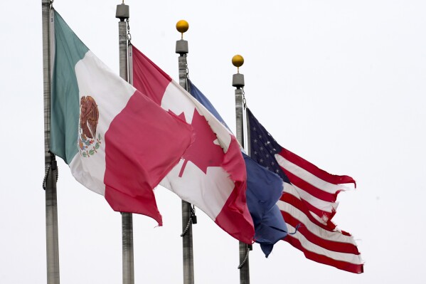 The flags of Mexico, Canada and the United States are shown near the Ambassador Bridge, Monday, Feb. 3, 2025, in Detroit. (AP Photo/Paul Sancya, File)
