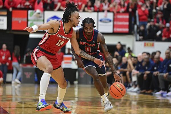 Detroit Mercy guard Antoine Davis, right, drives against Youngstown State guard John Lovelace Jr. during the first half of an NCAA college basketball game in the quarterfinals of the Horizon League tournament, Thursday, March 2, 2023, in Youngstown, Ohio. (AP Photo/David Dermer)