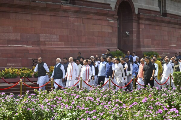 Indian Prime Minister Narendra Modi, second left, with other lawmakers walks in a procession to enter the new Parliament building, in New Delhi, India, Tuesday, Sept.19, 2023. The new building was built at an estimated cost of $120 million. It's part of a $2.8 billion revamp of British-era offices and residences in central New Delhi. (AP Photo)