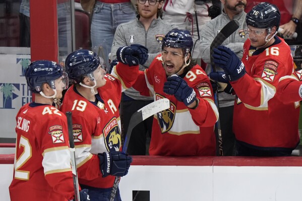 Teammates congratulate Florida Panthers left wing Matthew Tkachuk (19) after Tkachuk scored an empty-net goal during the third period of Game 1 of the first-round of an NHL Stanley Cup Playoff series against the Tampa Bay Lightning, Sunday, April 21, 2024, in Sunrise, Fla. (AP Photo/Wilfredo Lee)