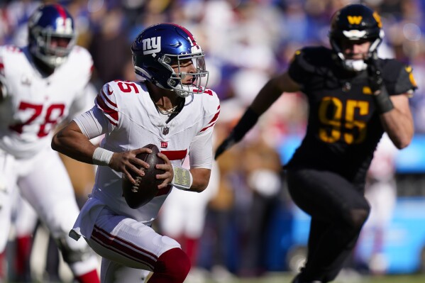 New York Giants quarterback Tommy DeVito (15) scrambles out of the pocket as he is chased by Washington Commanders defensive end Casey Toohill (95) during the first half of an NFL football game, Sunday, Nov. 19, 2023, in Landover, Md. (AP Photo/Stephanie Scarbrough)