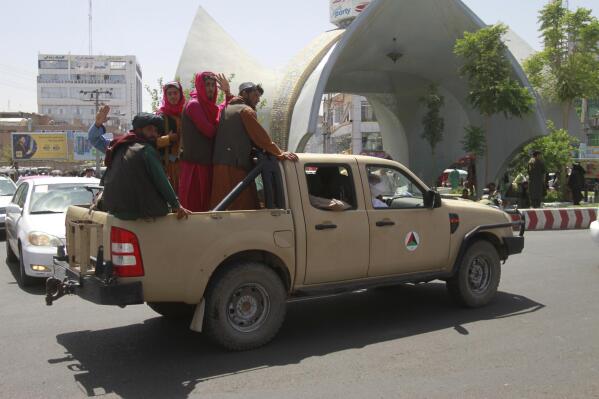 Taliban fighters pose on the back of a vehicle in the city of Herat, west of Kabul, Afghanistan, Saturday, Aug. 14, 2021, after they took this province from Afghan government. The Taliban seized two more provinces and approached the outskirts of Afghanistan’s capital. (AP Photo/Hamed Sarfarazi)