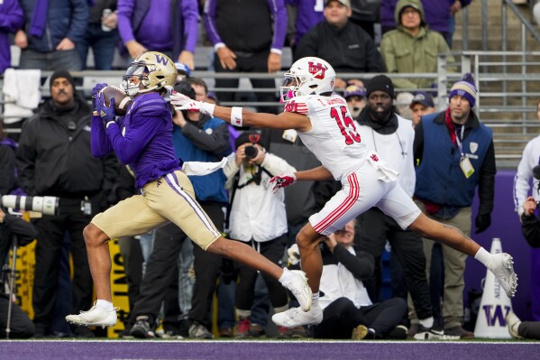 Washington wide receiver Rome Odunze, left, makes a touchdown catch in front of Utah cornerback Tao Johnson (15) during the first half of an NCAA college football game Saturday, Nov. 11, 2023, in Seattle. (AP Photo/Lindsey Wasson)