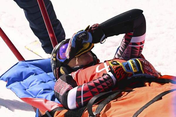 Italy's Federica Brignone is carried away on a toboga after she broke multiple bones in her left leg during a giant slalom crash at the Italian championships in the Lusia ski area, in Val di Fassa, Italy, Thursday, April 3, 2025. (AP Photo/Elvis Piazzi)