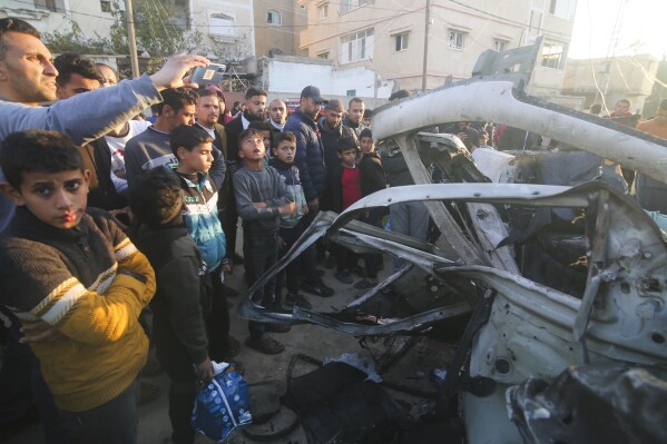 Palestinians gather around a Hamas police vehicle after it was struck by an Israeli airstrike in Rafah, Gaza Strip, Tuesday, Feb. 6, 2023. (AP Photo/Hatem Ali)