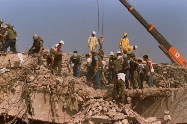 FILE - Rescue workers sift through the rubble of the U.S. Marine base in Beirut in Oct. 23, 1983 following a massive bomb blast that destroyed the base and killed 241 American servicemen. Iran told the United Nation’s highest court on Monday, Sept. 19, 2022, that Washington’s confiscation of some $2 billion in assets from Iranian state bank accounts to compensate bombing victims was an attempt to destabilize the Iranian government and a violation of international law. The U.S. Supreme Court in 2016 ruled money held in Iran’s central bank could be used to compensate victims of the 1983 bombing linked to Iran. (AP Photo, File)