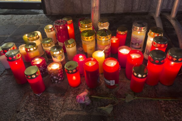 Candles are lit at the site of a stabbing attack in Villach, Austria, Sunday, Feb. 16, 2025. (AP Photo/Darko Bandic)